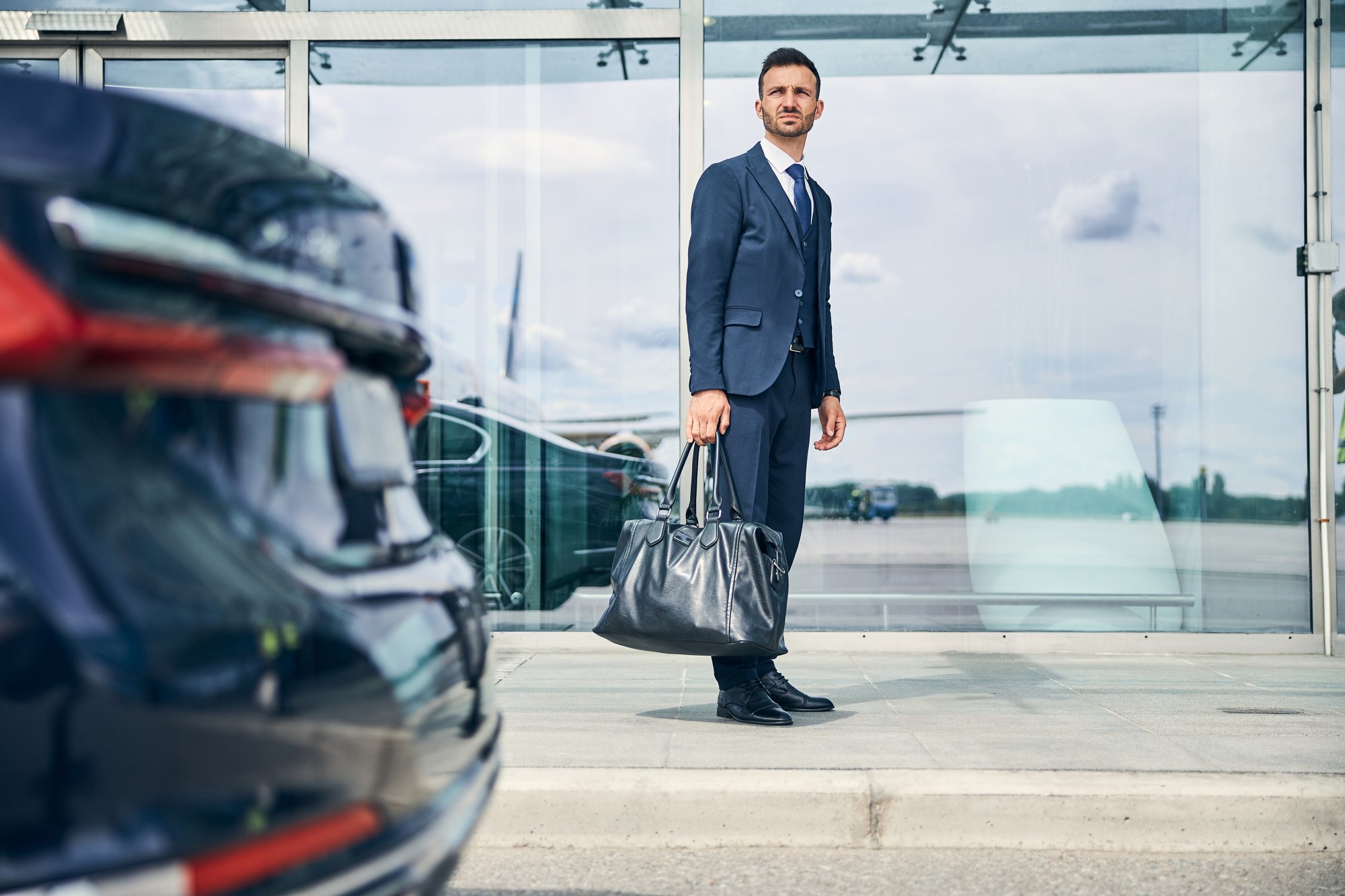 elegant-businessman-waiting-for-a-shuttle-bus-near-BHV6XE9